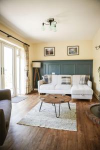 a living room with a white couch and a coffee table at Ger Yr Afon in Saint Harmon