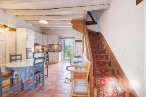 a kitchen and a dining room with a staircase in a house at Maison Des Hôtes - Dordogne in Saint-Crépin-dʼAuberoche