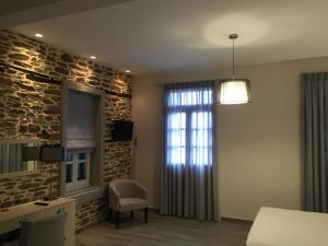 a living room with a stone wall and a window at Klities Guest House in Polygryos