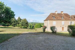 an old house in a field with a gravel driveway at Maison Des Hôtes - Dordogne in Saint-Crépin-dʼAuberoche