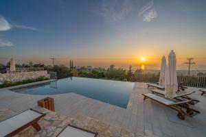a swimming pool with two umbrellas and a sunset at Hellosummer Boutique suites,near fiscardo! in Andipáta Erísou +79 photos