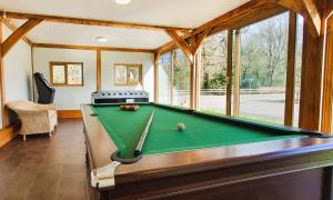 a pool table in a living room with a pool table at The Victorian Barn, Self-Catering Holidays with Pool and Hot Tubs, Dorset in Woolland