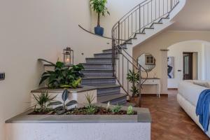 a staircase in a living room with plants at Villa Greta in Porto San Giorgio