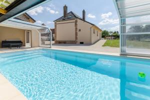 a swimming pool in front of a house at Le saint remeau in Le Jard