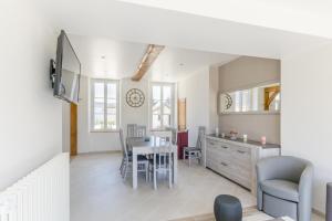 a living room with a table and a dining room at Le saint remeau in Le Jard