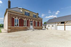 an old brick house with a driveway in front of it at Le saint remeau in Le Jard