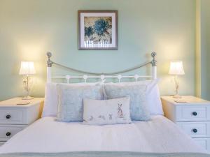 a bedroom with a white bed with two night stands at Meadow View-Uk34416 in Cheddar +8 photos