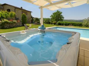 a pool with a hot tub in a backyard at Villa Vineyard View by Interhome in San Gimignano