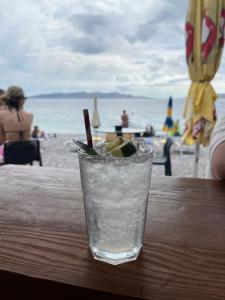 ein Getränk steht auf einem Tisch am Strand in der Unterkunft Guesthouse Donko 1 & 2 in Senj