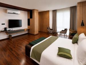 a hotel room with a bed and a flat screen tv at Nandan Inn in Dibrugarh