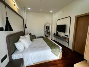 a bedroom with a bed with a mirror and a television at Nandan Inn in Dibrugarh +9 photos