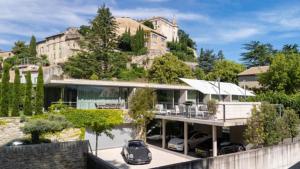 a house with a car parked in front of it at Le Pavillon M, Piscine et Spa au pied du château, Petit-Déjeuner inclus, Parking privé in Grignan