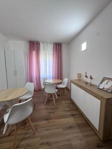 a living room with a table and chairs and a table and a table and chairs at aliseo in Olbia