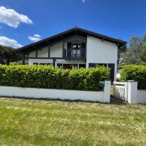 a white house with a fence in front of it at Gîte chez PAT in Ychoux +24 photos