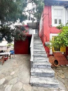 a staircase leading up to a red building with a table at Thassos Traditional House in Limenaria