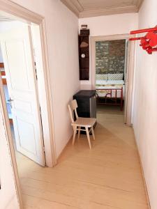 a room with a chair and a desk and a window at Thassos Traditional House in Limenaria
