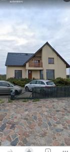 a house with two cars parked in front of it at Agroturystyka Matłak in Matłak