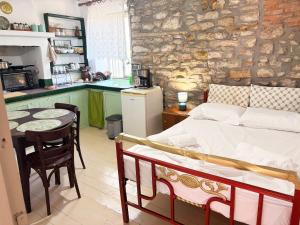 a bedroom with a bed and a kitchen with a table at Thassos Traditional House in Limenaria