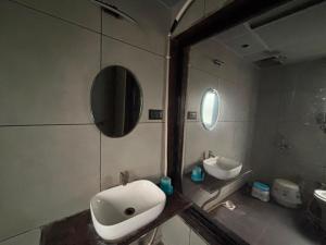 a bathroom with a sink and a mirror at Shree Hariraj Guest House in Vapi