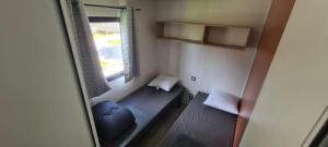 a small room with a bed and a window at Camping 3 étoiles - Piscine - ccbgbi0 in Lavelanet