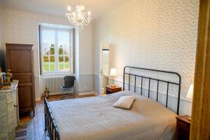 a bedroom with a bed and a window and a chair at Château de Saint Clair in Saint-Clair-sur-lʼElle