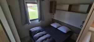 a small bed in a small room with a window at Camping 3 étoiles - Piscine - ccbgbi0 in Lavelanet