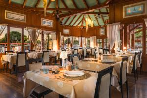 a dining room with white tables and chairs at Elba Carlota Beach & Golf Resort in Caleta De Fuste