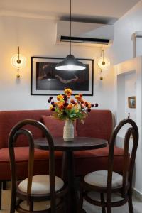 a table with a vase of flowers and two chairs at Habitat Service Apartment in Ilado +45 photos