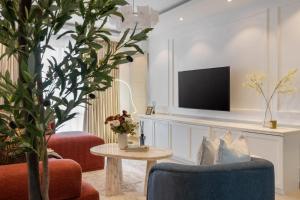 a living room with two chairs and a tv at Habitat Service Apartment in Ilado