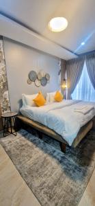 a bedroom with a large bed with yellow pillows at Habitat Service Apartment in Ilado