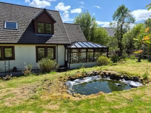 a house with a pond in the yard at Tylone in Lochdon