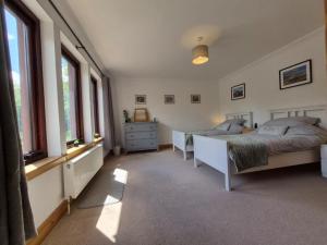 a bedroom with two beds and two windows at Tylone in Lochdon