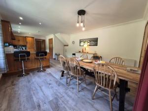 a dining room with a wooden table and chairs at Tylone in Lochdon
