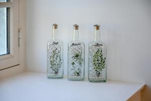 three glass bottles sitting on a counter next to a window at Château de Saint Clair in Saint-Clair-sur-lʼElle