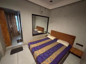 a bedroom with a bed and a large mirror at Shree Hariraj Guest House in Vapi +22 photos