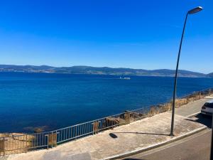 a view of a large body of water with a street light at Hotel Siroco Portonovo in Sanxenxo
