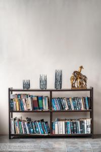 a book shelf filled with books next to a wall at The Montfort - Kandy in Kandy