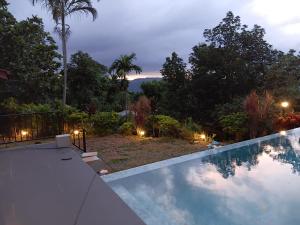 a swimming pool in a backyard at night at The Montfort - Kandy in Kandy +31 photos