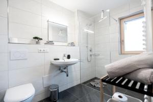a white bathroom with a sink and a toilet at FeWo Iller im Allgäu in Sonthofen