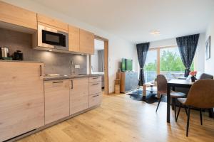a kitchen with wooden cabinets and a dining room with a table at FeWo Iller im Allgäu in Sonthofen