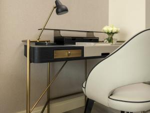 a desk with a lamp and a white chair at Fairmont Ramla Riyadh in Riyadh +175 photos