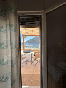 an open door to a patio with a table and an umbrella at Sea View Studios, Harbour Beach, Bali in Bali