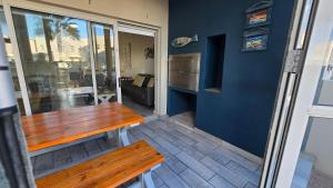 a porch with a wooden bench and a blue wall at La Palma villas 6 in Mossel Bay