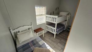 a reflection of a bedroom with two beds and a window at La Palma villas 6 in Mossel Bay