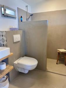 a bathroom with a white toilet and a sink at Unique Robinson-House with breathtaking seaview in Podšpilje