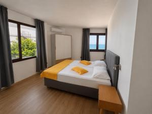 a bedroom with a bed with a mirror and windows at Palma Beach Hotel in Kranevo