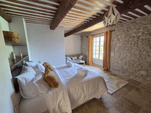 a bedroom with a large white bed with a stone wall at MAS de 1676 in Mallemort +5 photos