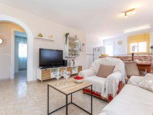 a living room with a couch and a tv at Holiday Home Panoramic by Interhome in Tordera