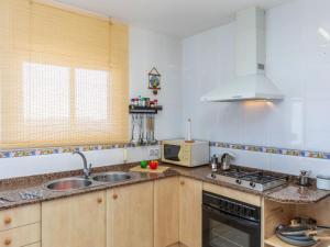 a kitchen with a sink and a stove and a microwave at Holiday Home Panoramic by Interhome in Tordera