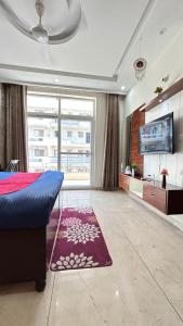 a bedroom with a blue bed and a large window at Utk 3 in Panchkula